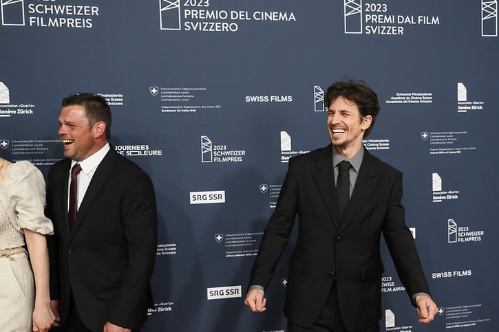 Le réalisateur du film "Drii Winter" Michael Koch (à droite) arrive sur le tapis rouge lors de la remise du Prix du cinéma suisse vendredi au Bâtiment des Forces Motrices à Genève. © KEYSTONE/JEAN-CHRISTOPHE BOTT